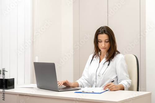 Doctor explaining with patient via laptop computer, mobile health application.