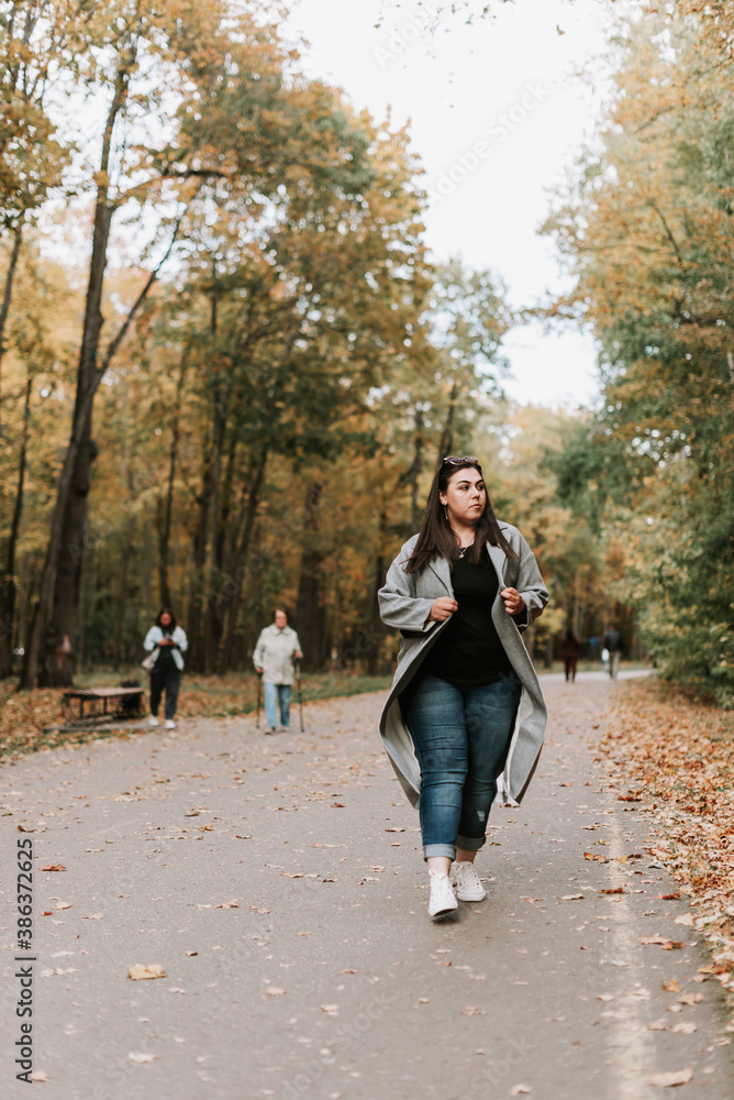 Beautiful woman in a gray coat on an autumn alley Beautiful woman in a gray coat on an autumn alley