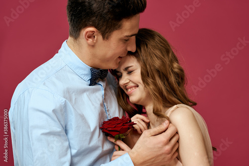 Lovers people with rose in hands on pink isolated background hug emotions happiness romance feelings