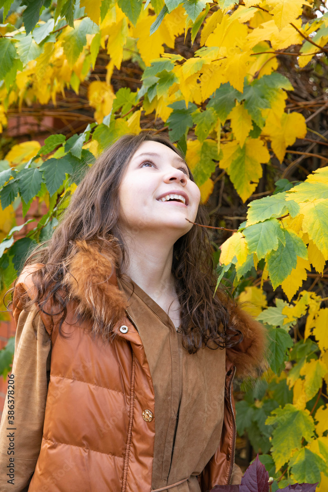 Autumn. Girl on a background of yellow - green leaves. Happy Autumn. Girl on a background of yellow - green leaves. Happy