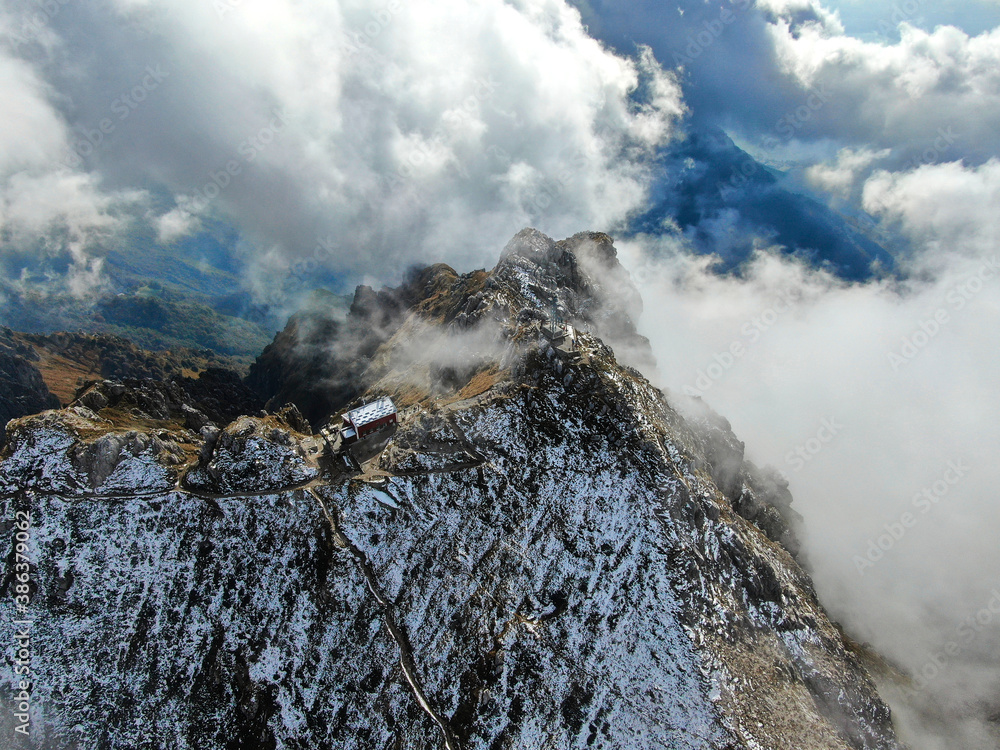 The top of Mount Resegone with snow and surrounded by clouds. This mountaintop is close to Lake Como in northern Italy, 