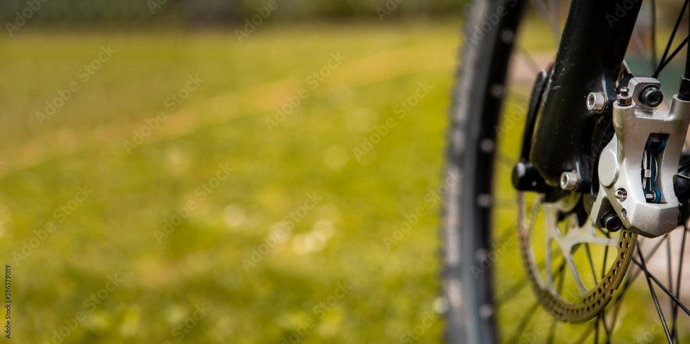 Fototapeta premium Close-up of a mountain bike brake system. See worn brake disc and hydraulic brake mechanism. Copy space