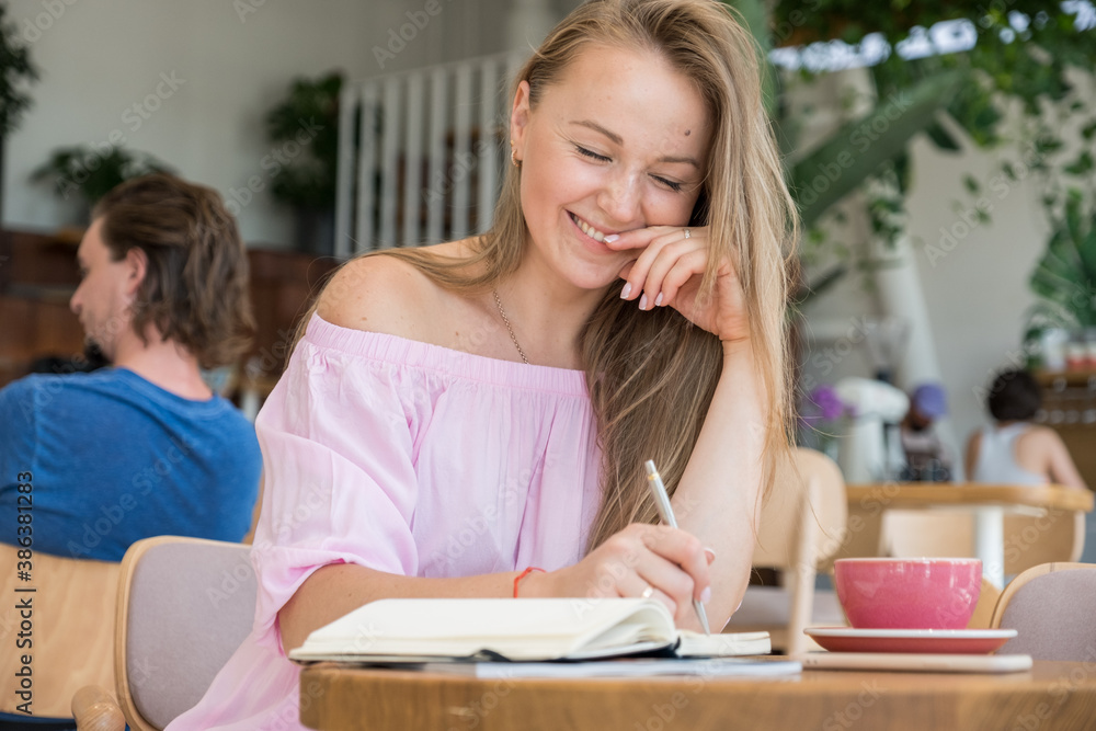Woman sitting in cafe drinking coffee and planing her agenda. She alone in beautiful place, relaxing and dreaming about future. Woman sitting in cafe drinking coffee and planing her agenda. She alone in beautiful place, relaxing and dreaming about future.