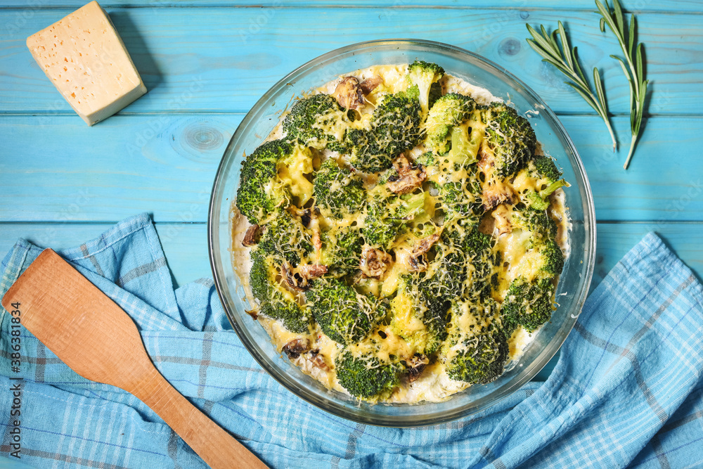 Broccoli cheddar egg casserole in baking dish on blue wooden background. Broccoli cheddar egg casserole in baking dish on blue wooden background.