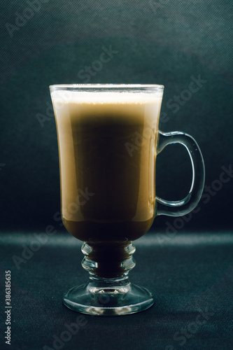 Creamy Irish coffee in a glass on black background. Shallow depth of field, blur, whiskey, drink, bokeh, Christmas.