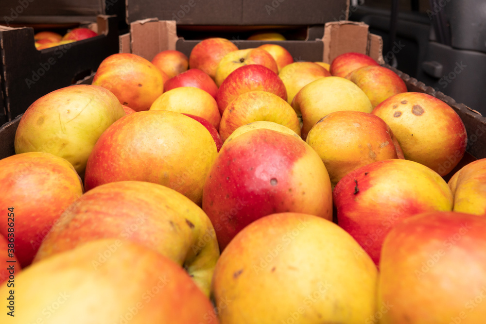 fresh apples in a box on a wooden table, top view