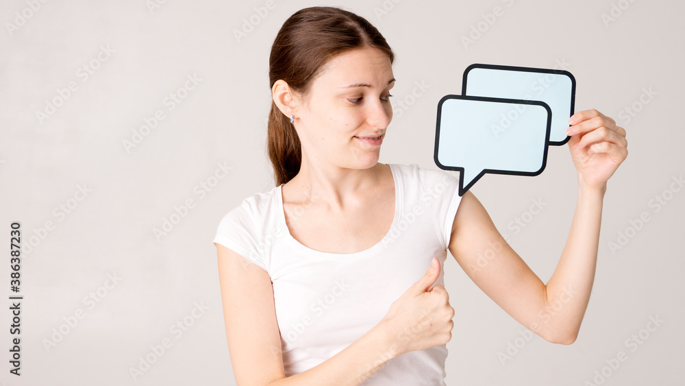 mid adult woman holding blank speech bubble on white background. Horizontal shape, front view, waist up, copy space