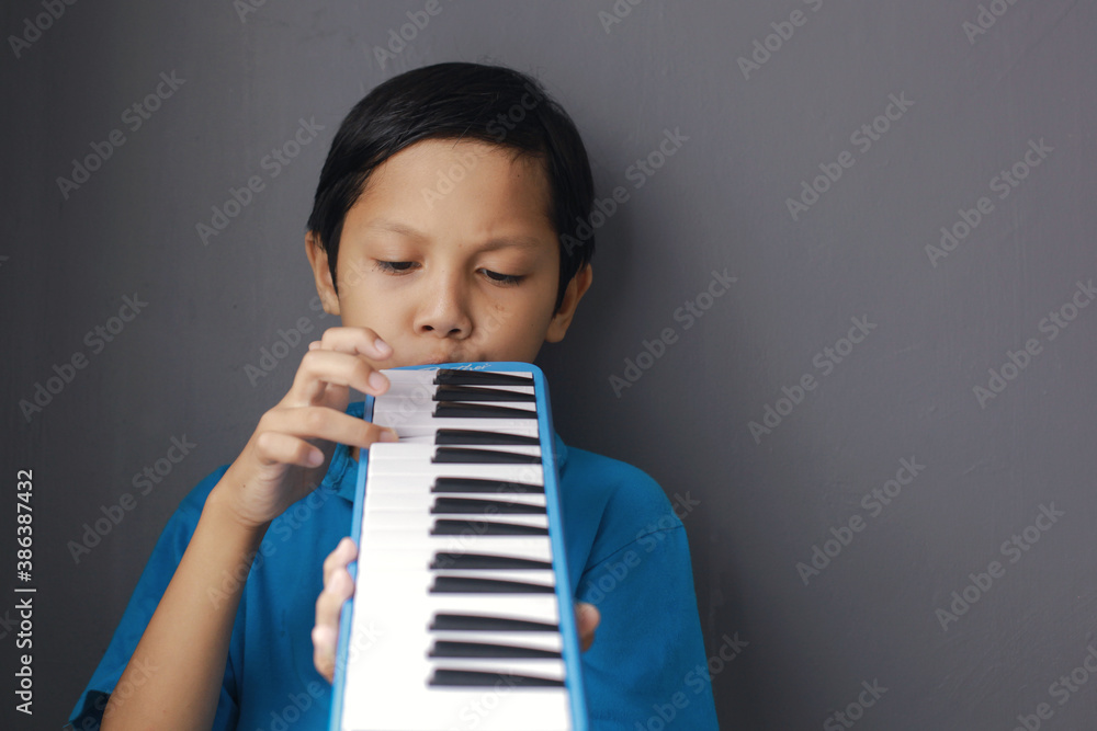 Boy playing blue melodeon musical instrument, melodica blow organ
