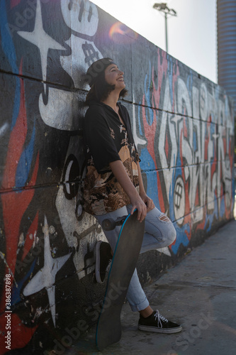 Mujer joven adolescente con skate monopatín en skatepark haciendo fotos selfies