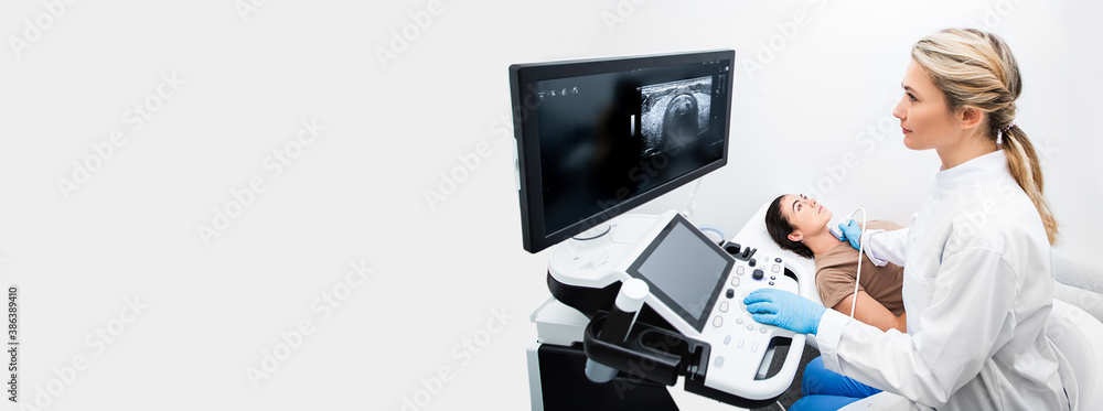 Ultrasound diagnostics of the thyroid gland. Woman endocrinologist making ultrasonography to a female patient in an ultrasound office of a modern clinic. Web banner