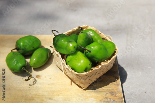 Fresh green Habanero Chili or Cabai Gendot in Indonesia on cutting board and wicker basket photo