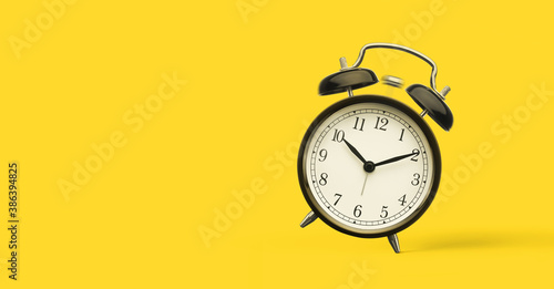 Close up of alarm clock isolated on yellow background with copy space