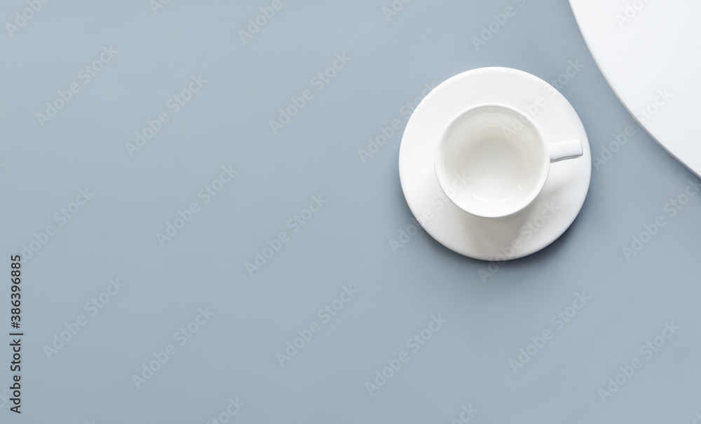 Empty white cup on blue and white background. Flat lay, top view, overhead. Mock up for drink. Minimalism.