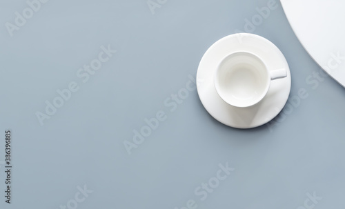 Empty white cup on blue and white background. Flat lay  top view  overhead. Mock up for drink. Minimalism.