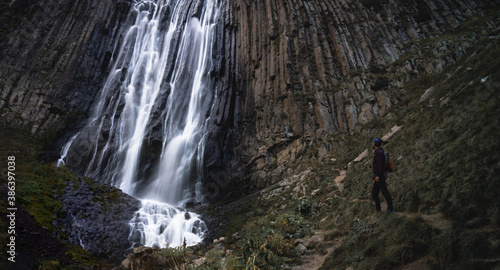 a man looks at a waterfall