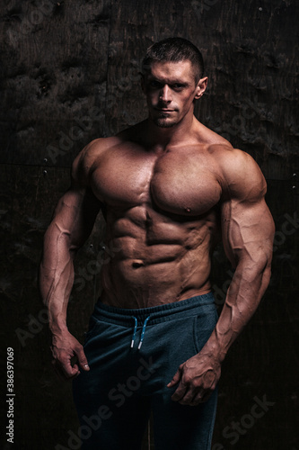Sporty and healthy muscular man on dark grunge background
