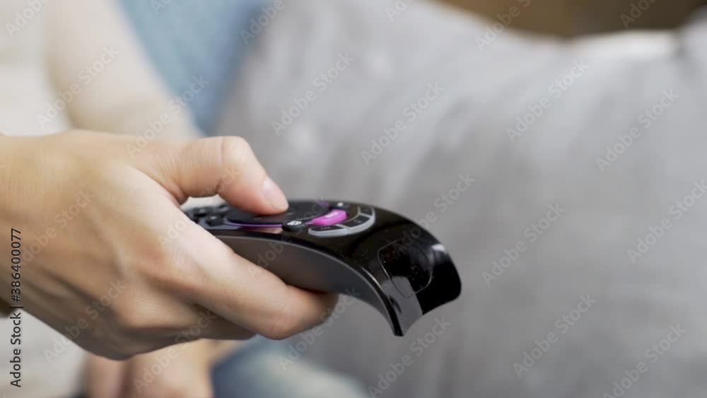 Close-up of a Woman's Hand Turning on TV Channels on the TV Control Panel. A Woman Watches TV and Female Fingers Press Buttons on the Remote Control, Macro. Close-up of a Woman's Hand Turning on TV Channels on the TV Control Panel. A Woman Watches TV and Female Fingers Press Buttons on the Remote Control, Macro.