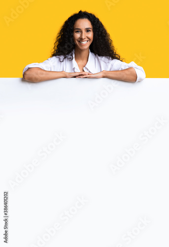 Free Place For Ad. Positive Lady Leaning On Blank White Advertisement Board