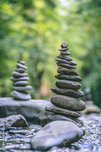 Relaxed view of a pyramid of stones balanced on a river water