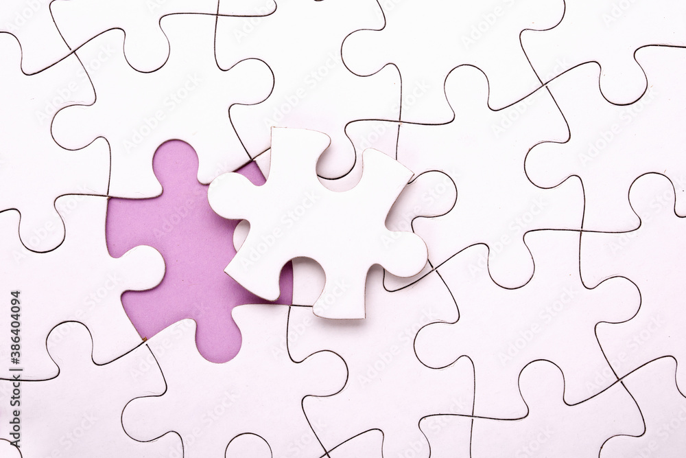 White jigsaw puzzle pieces on lila background. Horizontal composition with copy space. Business concept. White jigsaw puzzle pieces on lila background. Horizontal composition with copy space. Business concept.