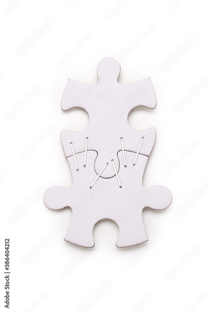 Two blank jigsaw puzzle pieces stapled together on a white background. Contains clipping path. Two blank jigsaw puzzle pieces stapled together on a white background. Contains clipping path.