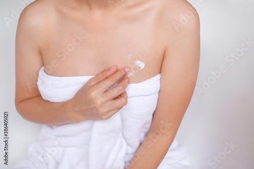 Woman applying cream,lotion on chest with white background, Beauty concept.