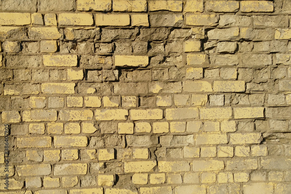 Old yellow dilapidated brick wall