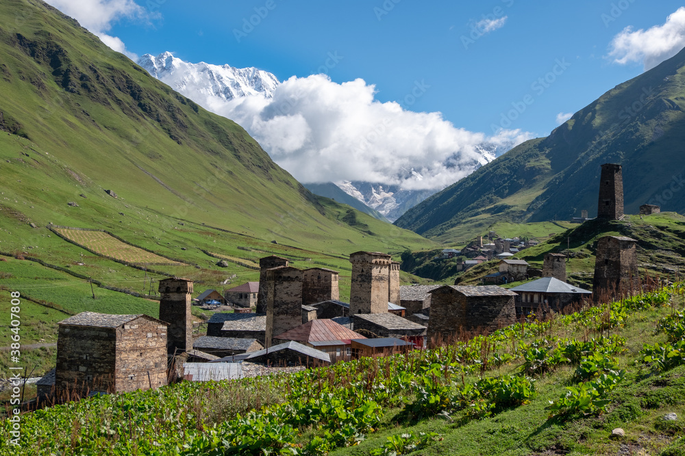 Obraz premium Ancient authentic village Ushguli, the Svaneti UNESCO World Heritage Site and one of the highest settlements in Europe. Bezengi wall and mount Shkhara, the highest mount in Georgia, on the background.