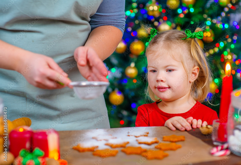 the little girl looks like mom is making Christmas gingerbread cookies