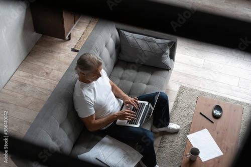 Middle-aged man working from home-office on laptop photo