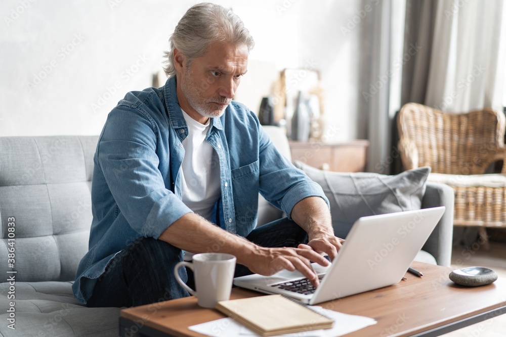 Middle-aged man working from home-office on laptop Middle-aged man working from home-office on laptop