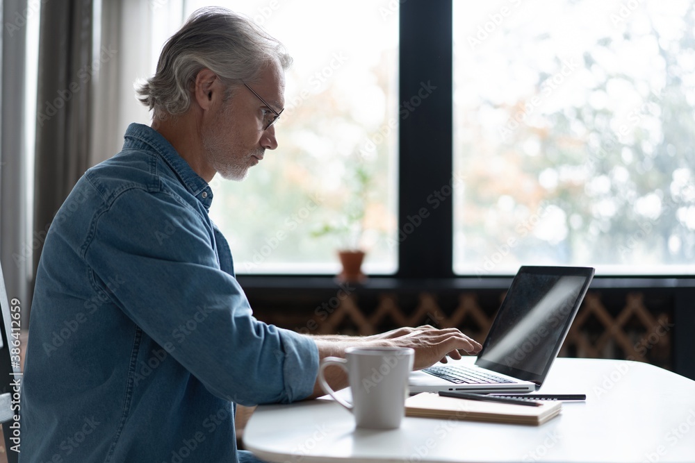 Middle-aged man working from home-office on laptop Middle-aged man working from home-office on laptop
