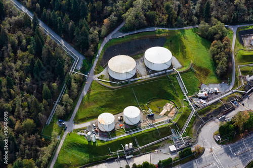 Aerial view of Oil Refinery Industrial Site in a modern city. White Holding Container Tanks. Taken in Port Moody, Vancouver, BC, Canada.