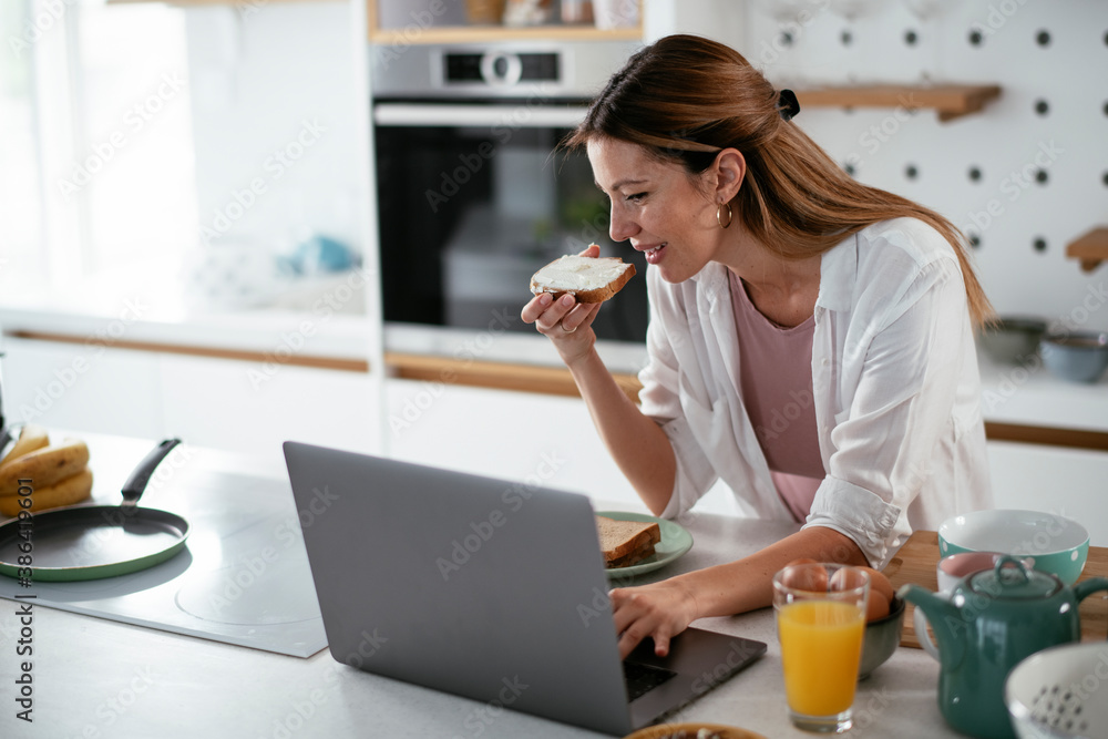 Beautiful woman eating breakfast in the kitchen. Young woman enjoys at home. Beautiful woman eating breakfast in the kitchen. Young woman enjoys at home.