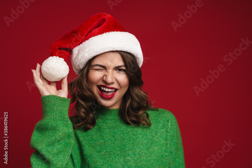 Beautiful happy girl in Santa Claus hat smiling and winking