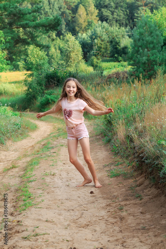 Beautiful teen girl  Is dancing outside at  summer sunset