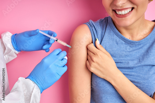 professional doctor giving vaccine shot to happy caucasian woman, positive and relaxed, prevention, protection and immunization concept. coronavirus, covid-19