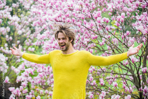 Spring season. Springtime concept. Unshaven man sniff bloom of magnolia. Man flowers background defocused. Spring beauty. Botany and nature. Happy spring concept. Hipster enjoy blossom aroma