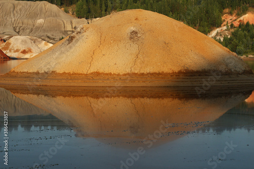 quarries in the place of mining and red refractory clay against the backdrop of red clay mountains and quarries photo