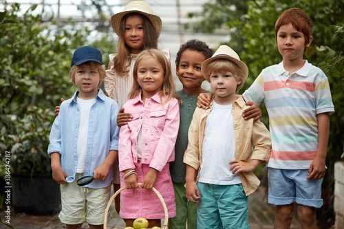 group of diverse kindergarten kids friends in garden  greenhouse. they gathered to learn ecology gardening