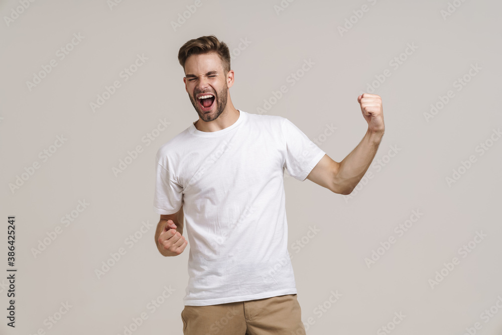 Delighted handsome guy screaming and showing winner gesture Delighted handsome guy screaming and showing winner gesture