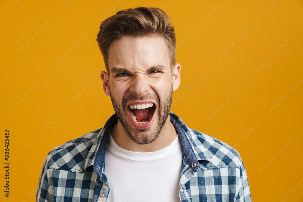 Angry handsome guy posing and screaming at camera Angry handsome guy posing and screaming at camera