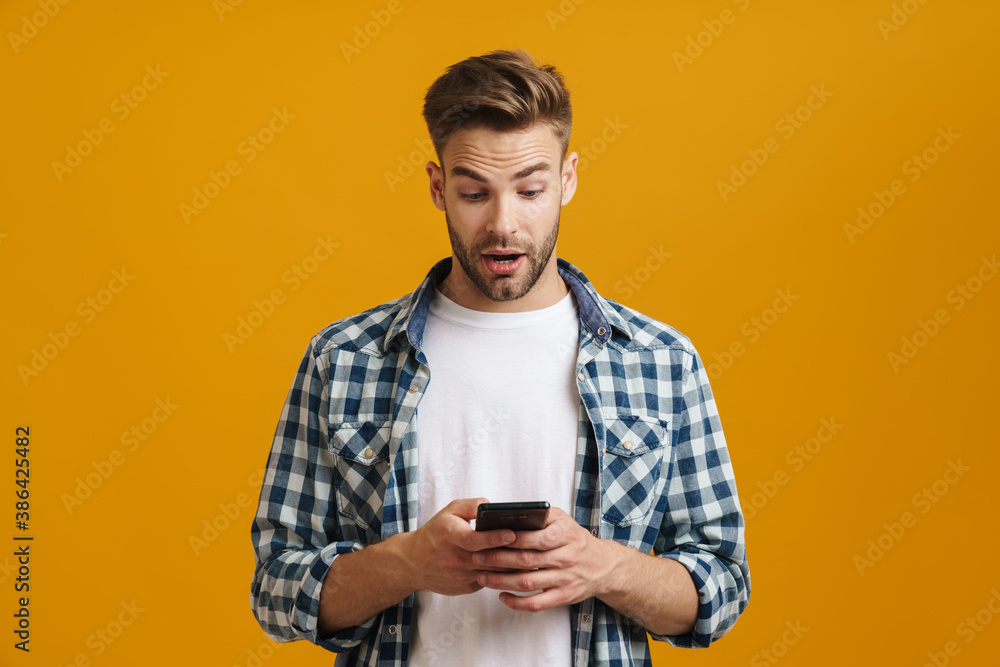 Caucasian handsome guy expressing surprise while using mobile phone Caucasian handsome guy expressing surprise while using mobile phone