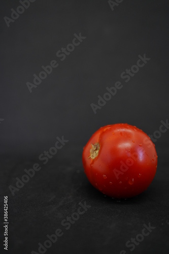 Red tomato on a black background
