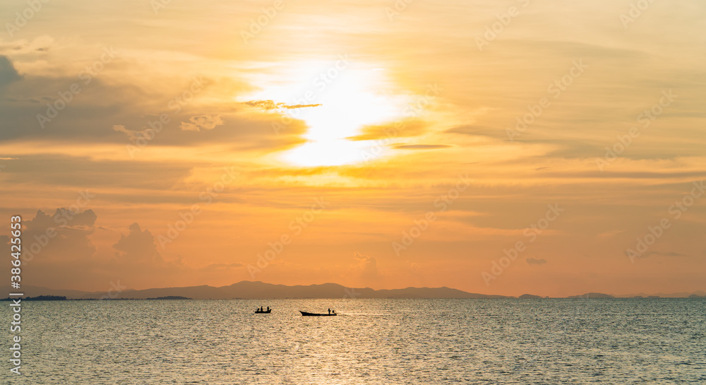 Sunset sky over sea in the evening with colorful sunlight, dusk sky and fishing boat on the sea