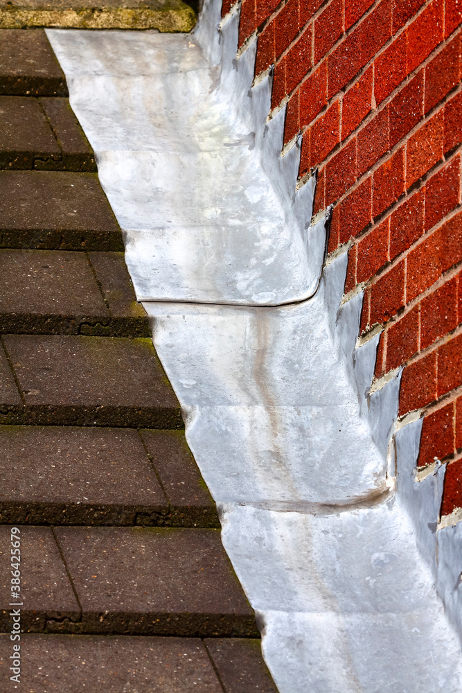 Stepped lead flashing roof gulley creating a water tight seal between