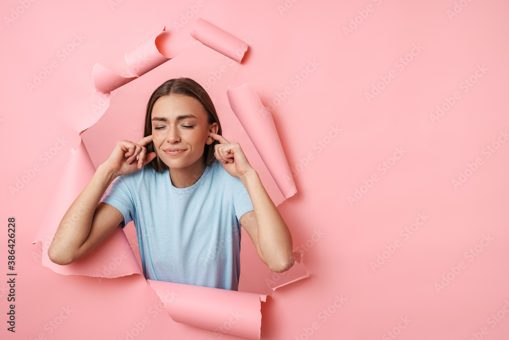 Fototapeta premium Young caucasian brunette woman plugging her ears with fingers