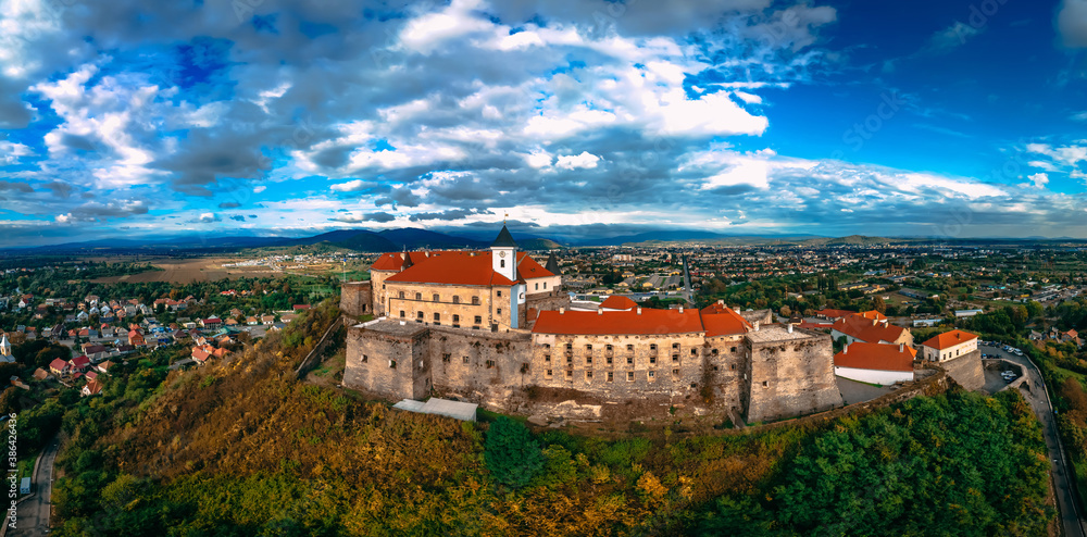 Aerial view of medieval castle on mountain in small european city in autumn season