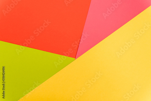 top view of colorful abstract yellow, red, green and pink paper background