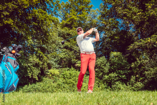 Golf player at the tee hitting ball far